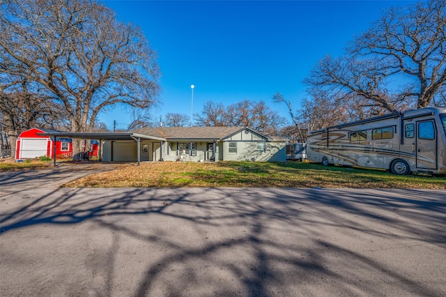 ranch-style house with a garage, a front yard, and a carport