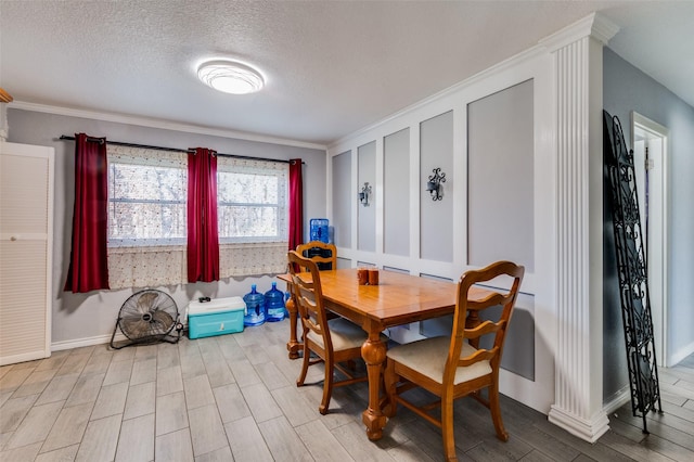 dining space featuring a textured ceiling, light hardwood / wood-style floors, and crown molding