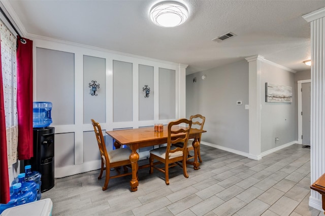 dining space with ornamental molding and a textured ceiling