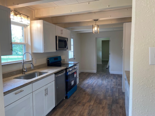 kitchen with appliances with stainless steel finishes, sink, pendant lighting, white cabinets, and dark hardwood / wood-style floors