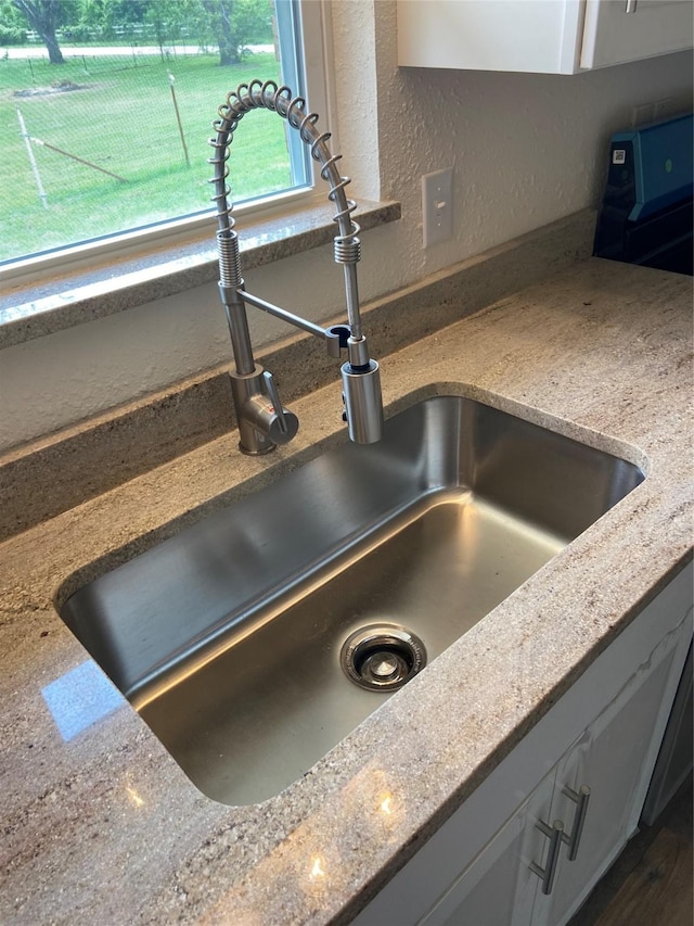 interior details featuring light stone counters and sink