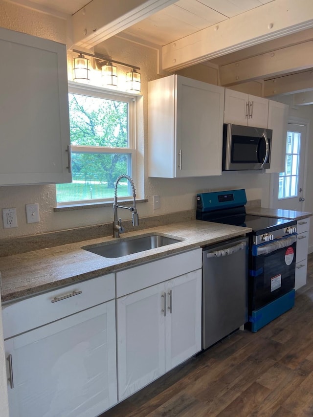 kitchen featuring plenty of natural light, appliances with stainless steel finishes, sink, and white cabinets