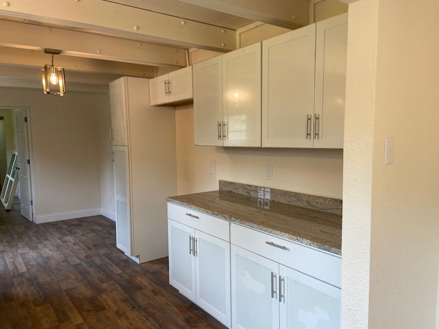 kitchen with light stone counters, beamed ceiling, and white cabinets