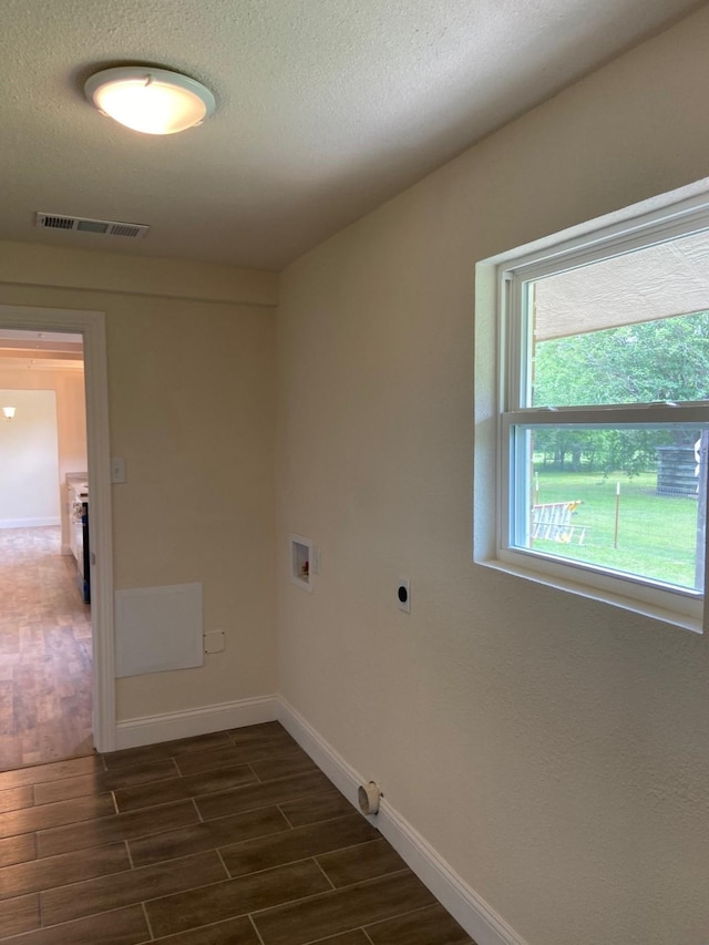 clothes washing area featuring washer hookup, dark hardwood / wood-style flooring, a textured ceiling, and electric dryer hookup