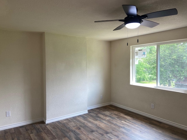 empty room featuring a textured ceiling, ceiling fan, and dark wood-type flooring