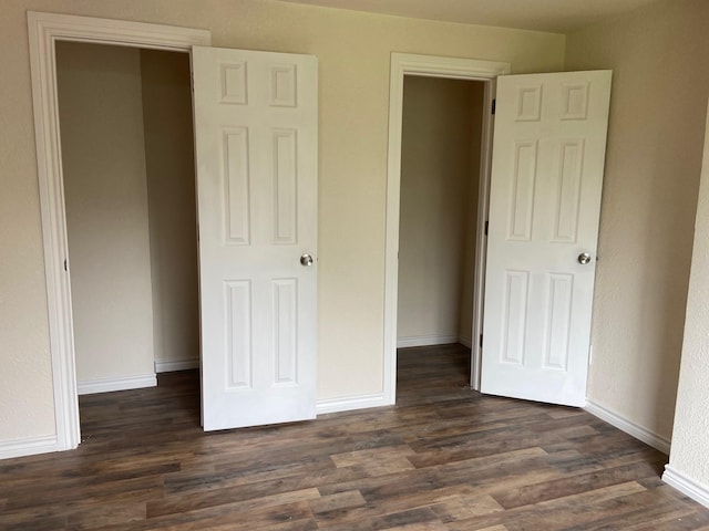 unfurnished bedroom with dark wood-type flooring