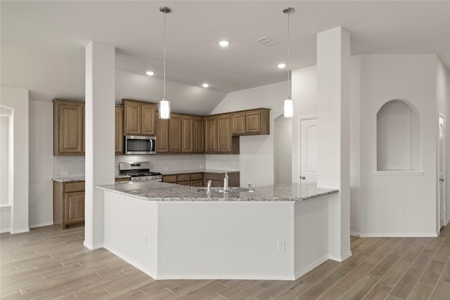 kitchen featuring sink, hanging light fixtures, lofted ceiling, and appliances with stainless steel finishes