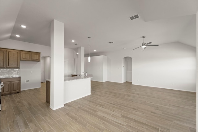 kitchen featuring light stone countertops, light hardwood / wood-style flooring, ceiling fan, and pendant lighting