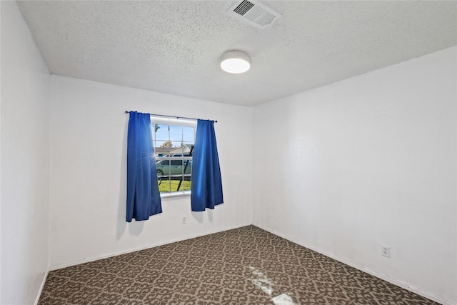 unfurnished room with a textured ceiling