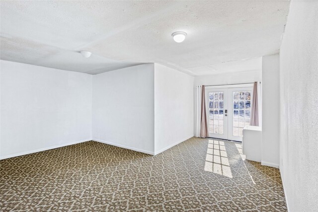 additional living space with a textured ceiling and french doors