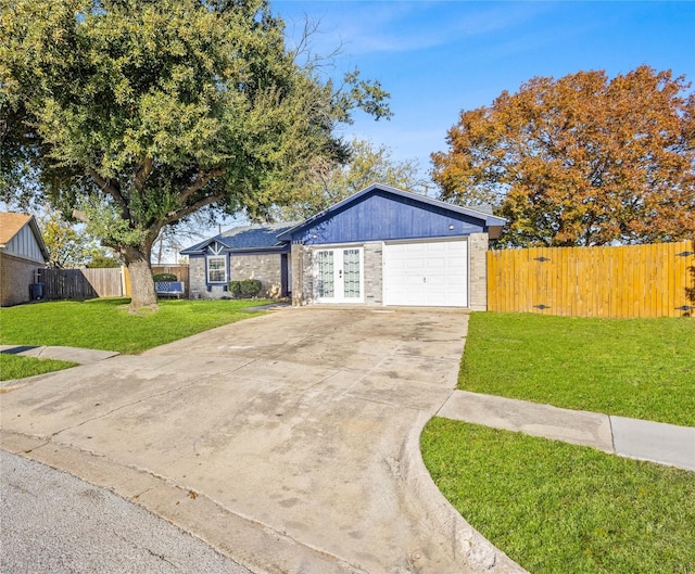 single story home with french doors, a front yard, and a garage