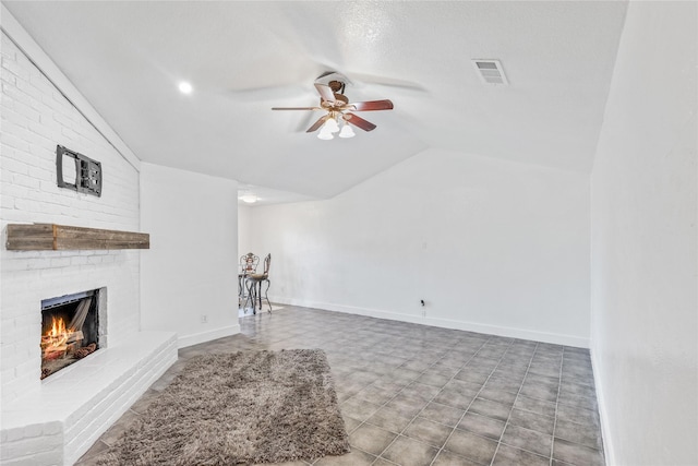 unfurnished living room featuring ceiling fan, lofted ceiling, and a fireplace