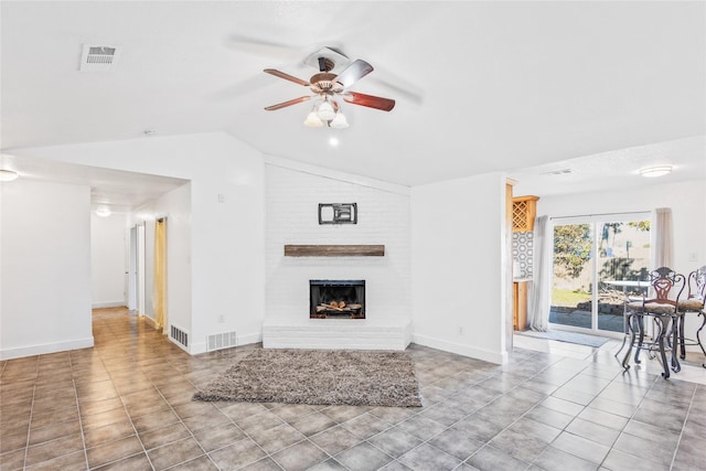 unfurnished living room featuring ceiling fan, a large fireplace, light tile patterned floors, and lofted ceiling