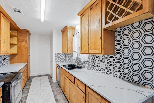 kitchen with appliances with stainless steel finishes, tasteful backsplash, sink, light stone counters, and a textured ceiling