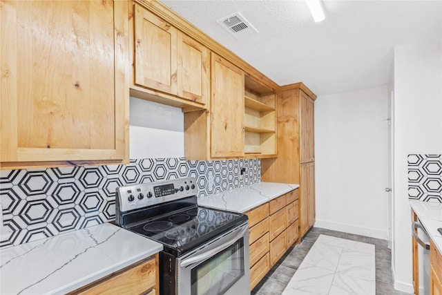 kitchen featuring appliances with stainless steel finishes, light brown cabinetry, backsplash, light stone counters, and a textured ceiling