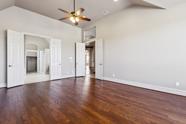 unfurnished bedroom with a spacious closet, ceiling fan, high vaulted ceiling, a closet, and hardwood / wood-style flooring