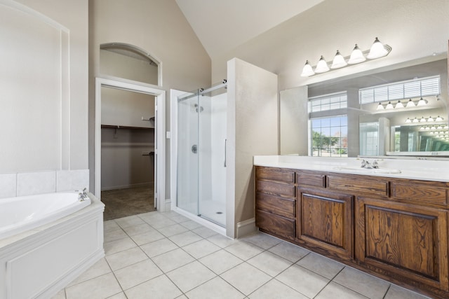 bathroom featuring tile patterned flooring, vanity, separate shower and tub, and vaulted ceiling