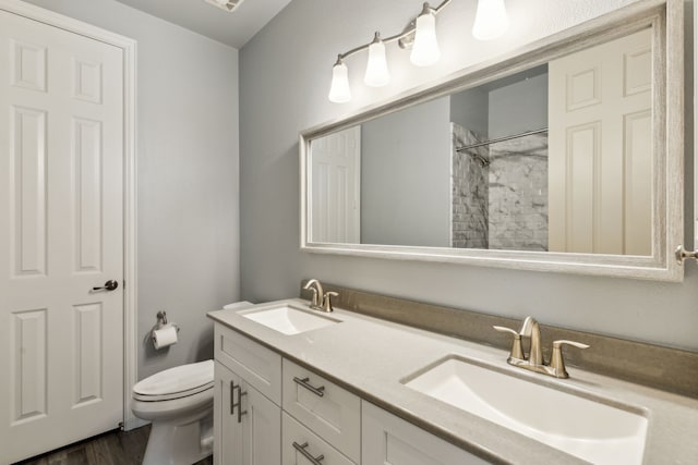 bathroom with walk in shower, hardwood / wood-style floors, vanity, and toilet