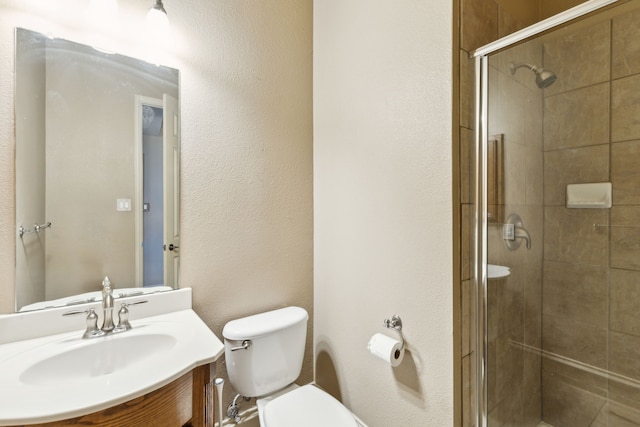 bathroom featuring vanity, toilet, and a shower with shower door