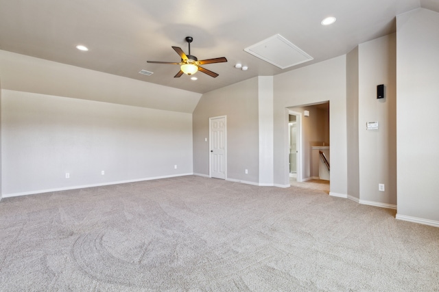 spare room featuring light carpet, vaulted ceiling, and ceiling fan