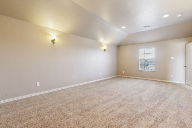 carpeted spare room with lofted ceiling