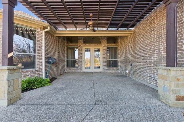 property entrance featuring a patio area, a pergola, and french doors