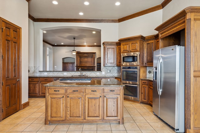 kitchen featuring ceiling fan, a center island, light tile patterned floors, and stainless steel appliances