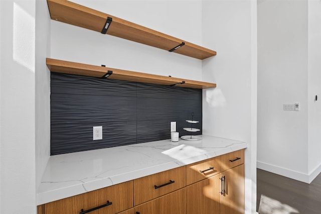 kitchen featuring light stone counters and dark wood-type flooring