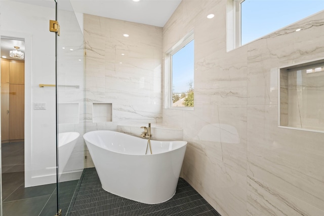 bathroom featuring a bathing tub, tile walls, and tile patterned floors