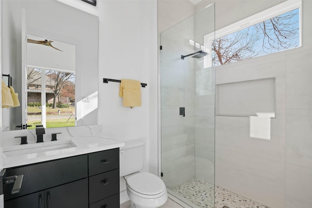 bathroom featuring ceiling fan, toilet, walk in shower, and vanity