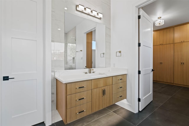 bathroom featuring tile patterned floors, vanity, and a tile shower