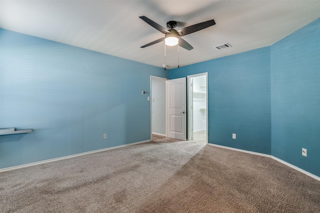 carpeted spare room featuring ceiling fan