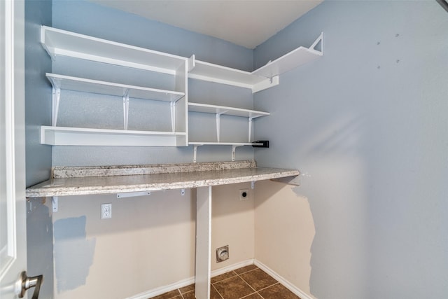 laundry area featuring dark tile patterned flooring and electric dryer hookup