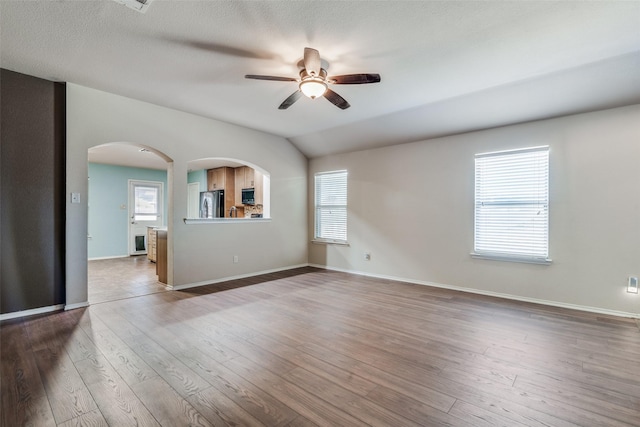 spare room featuring ceiling fan, lofted ceiling, and wood-type flooring