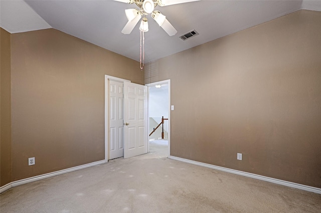 carpeted spare room featuring ceiling fan and lofted ceiling