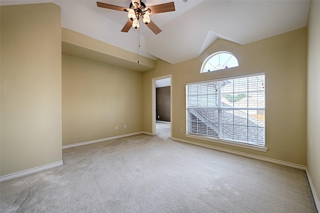 carpeted empty room with ceiling fan and high vaulted ceiling