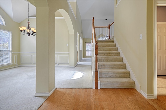 entrance foyer with hardwood / wood-style floors, a notable chandelier, and high vaulted ceiling