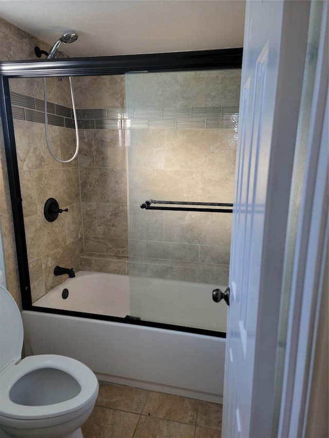 bathroom with shower / bath combination with glass door, tile patterned floors, and toilet