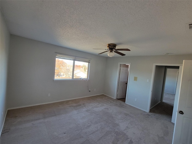 unfurnished bedroom featuring ceiling fan, light colored carpet, a textured ceiling, and a closet