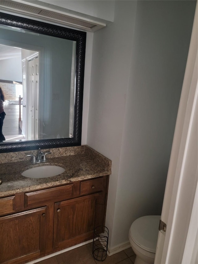 bathroom featuring tile patterned flooring, vanity, and toilet