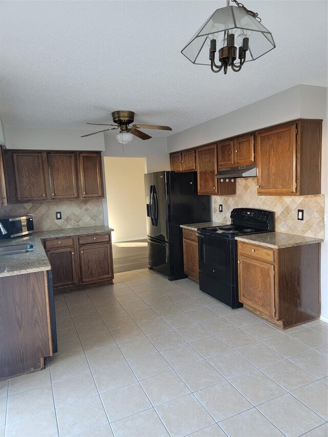 kitchen featuring decorative backsplash, light tile patterned flooring, black appliances, and ceiling fan with notable chandelier