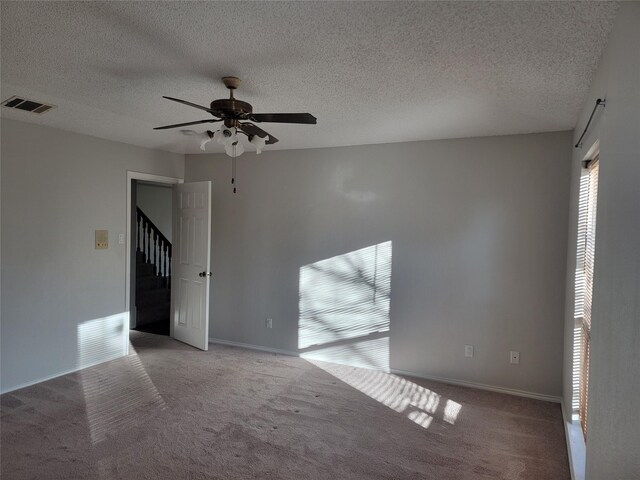 unfurnished room featuring light carpet, a textured ceiling, and ceiling fan