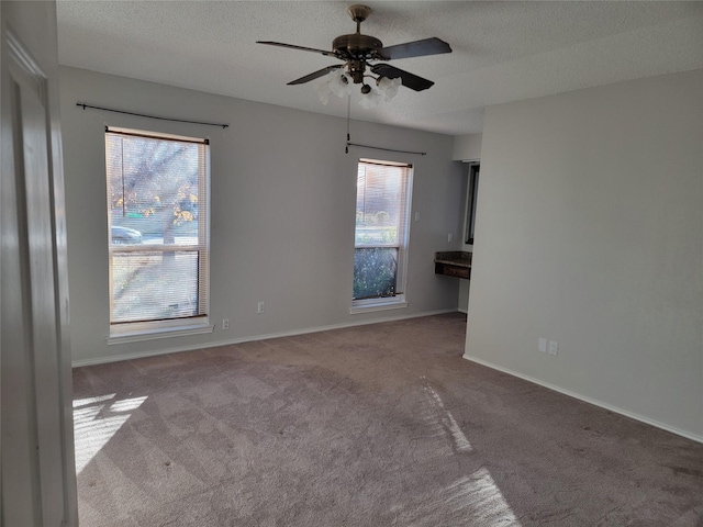 carpeted empty room with a textured ceiling and ceiling fan