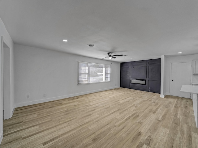 unfurnished living room featuring ceiling fan and light hardwood / wood-style floors