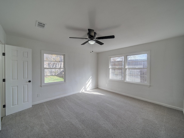 empty room with ceiling fan, carpet, and a healthy amount of sunlight