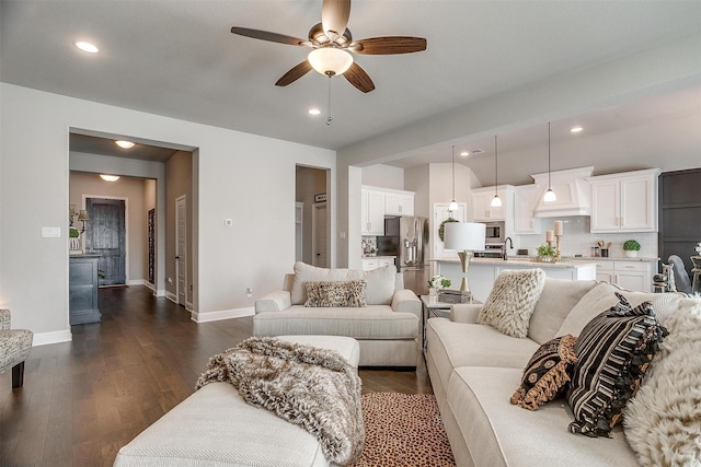 living room featuring ceiling fan, dark hardwood / wood-style flooring, and sink