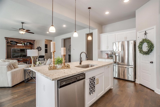 kitchen featuring a kitchen island with sink, white cabinets, sink, light stone countertops, and stainless steel appliances