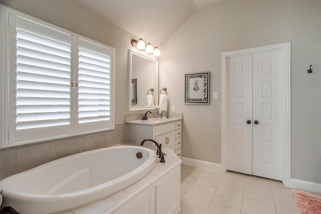 bathroom featuring vanity, a tub to relax in, tile patterned floors, and lofted ceiling