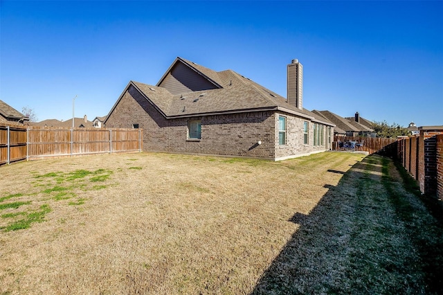 rear view of property featuring a yard