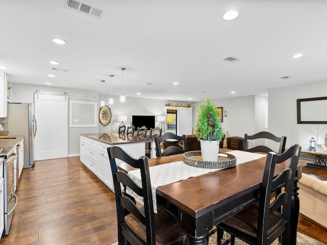 dining room featuring wood-type flooring and a barn door